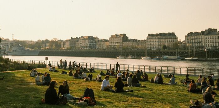 People sitting by the river in Nantes at sunset