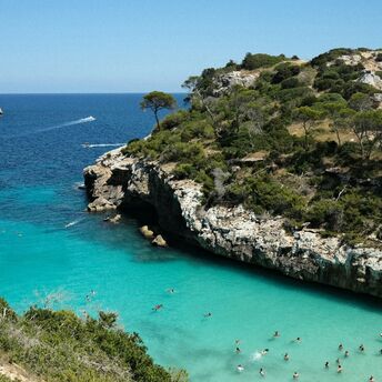 Turquoise cove with swimmers on Mallorca coast