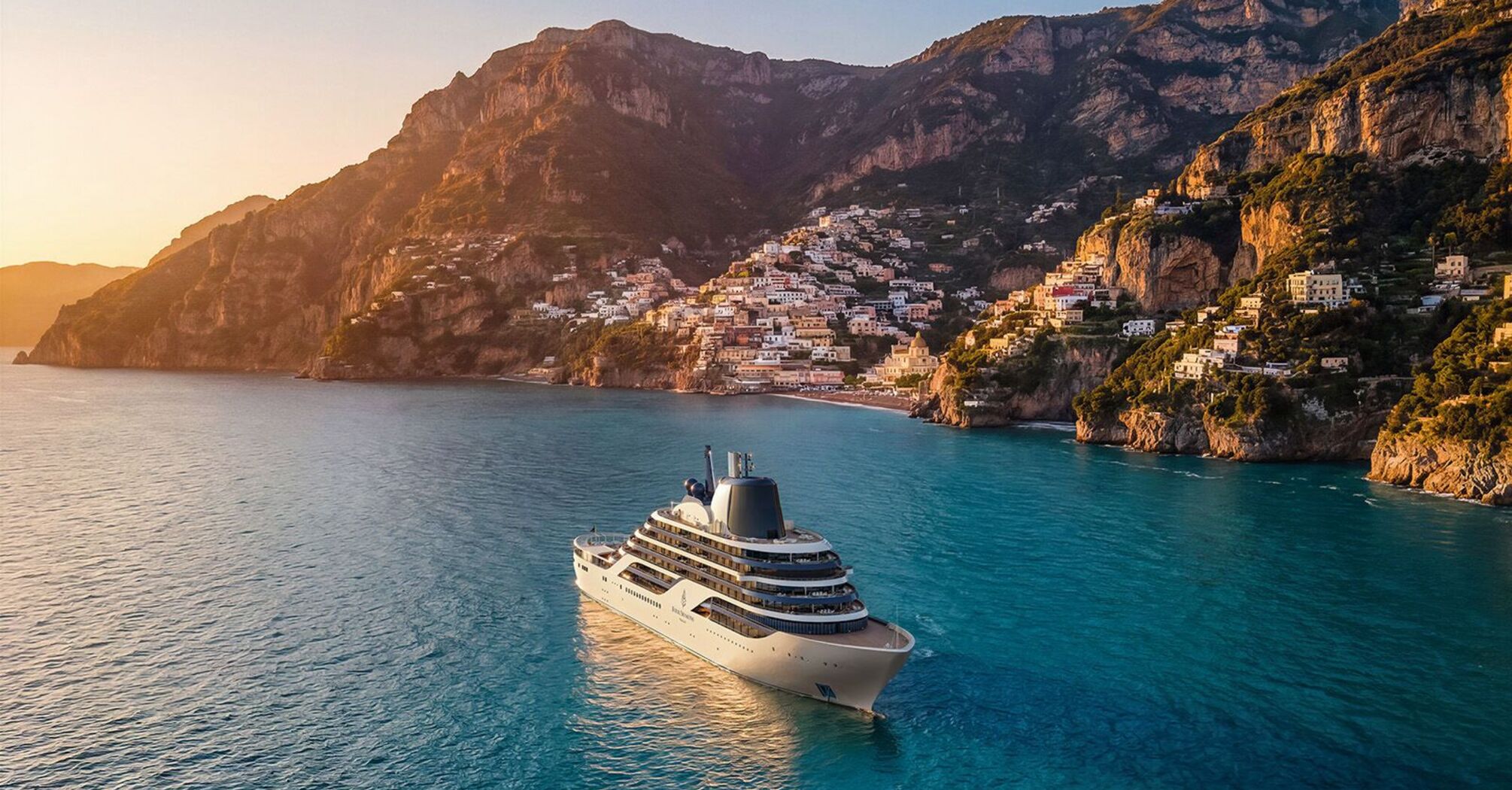 Four Seasons luxury yacht sailing along a coastal cliffside