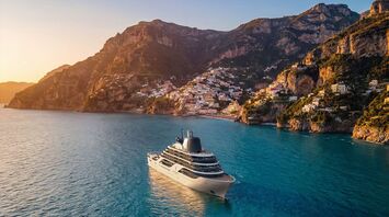 Four Seasons luxury yacht sailing along a coastal cliffside