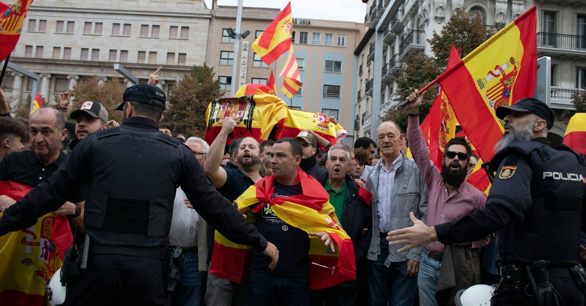 Protesters with Spanish flags near police officers