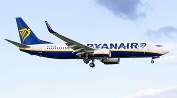 Ryanair aircraft landing against a blue sky