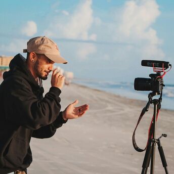 Content creator filming video on a beach