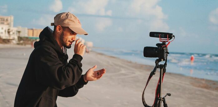Content creator filming video on a beach