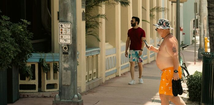 Shirtless man walking through a resort street