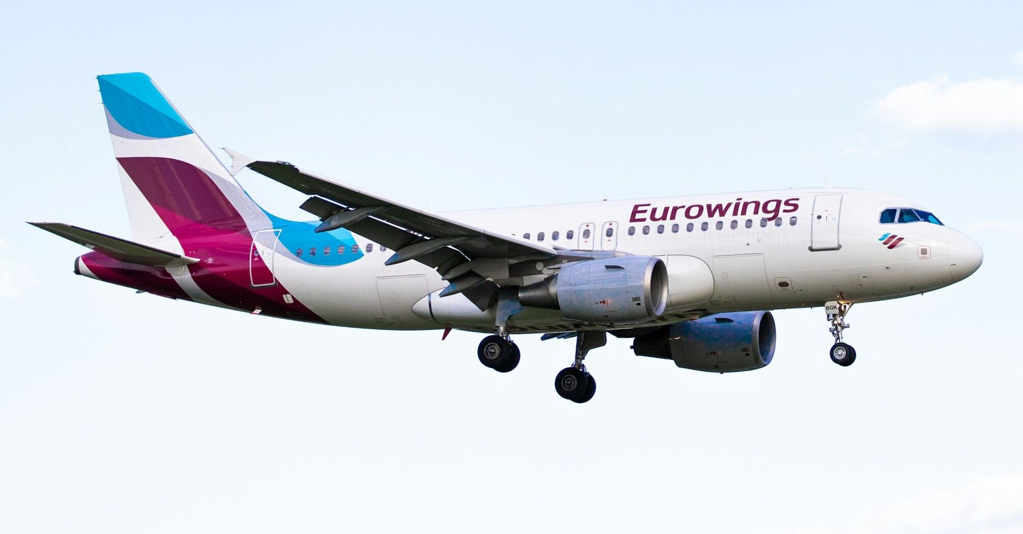 Eurowings aircraft flying against a pale blue sky