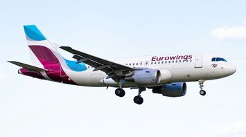 Eurowings aircraft flying against a pale blue sky