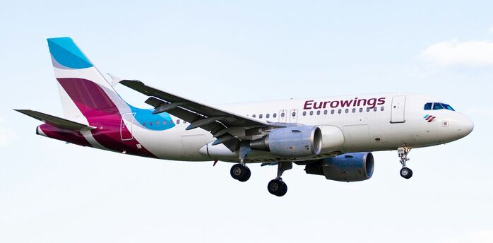 Eurowings aircraft flying against a pale blue sky