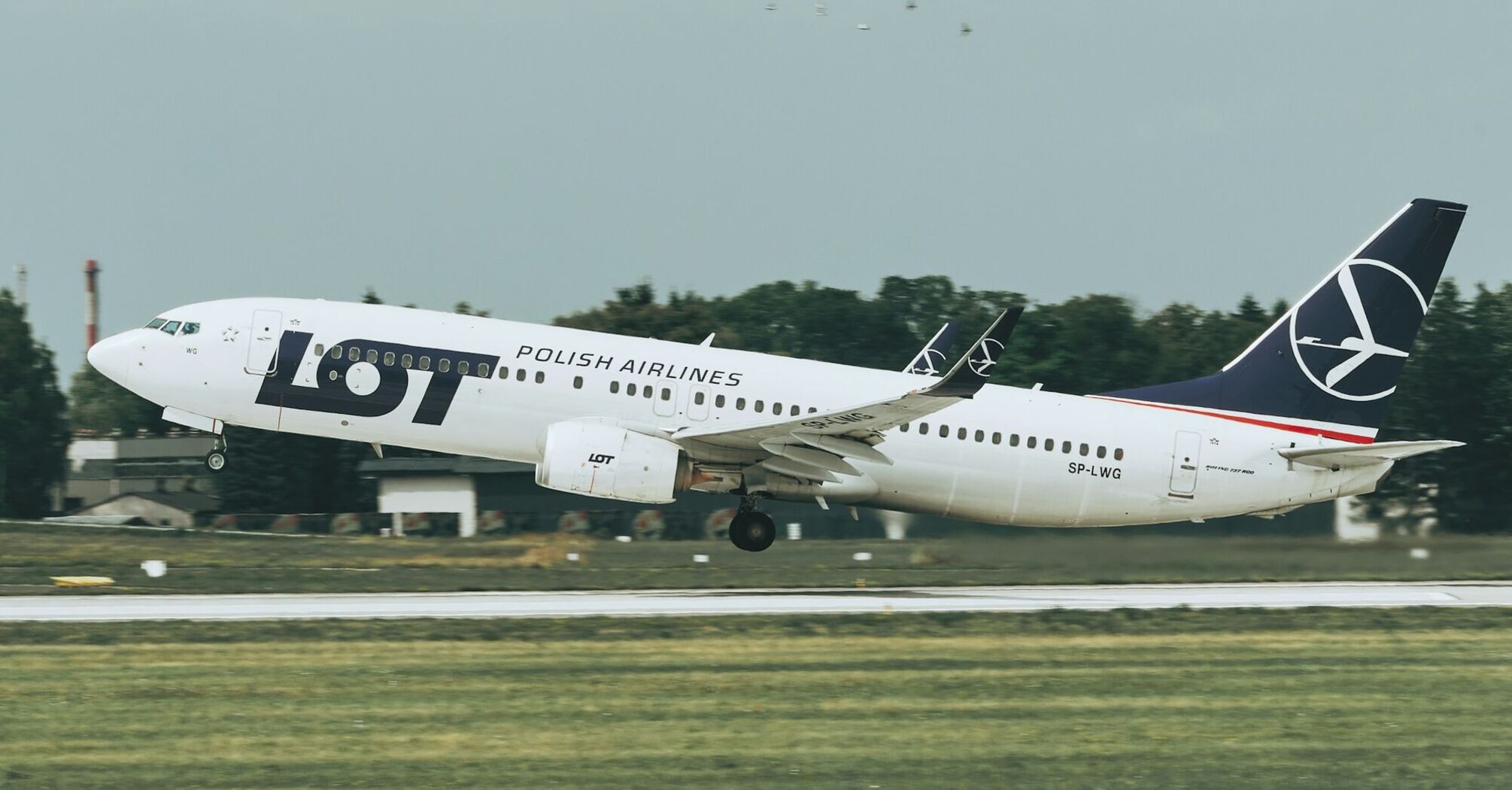 LOT Polish Airlines aircraft taking off from a runway