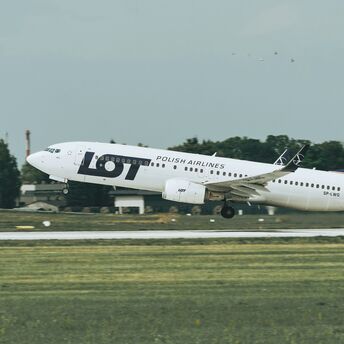 LOT Polish Airlines aircraft taking off from a runway