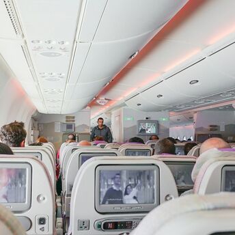 Passengers seated inside an aircraft cabin during a flight
