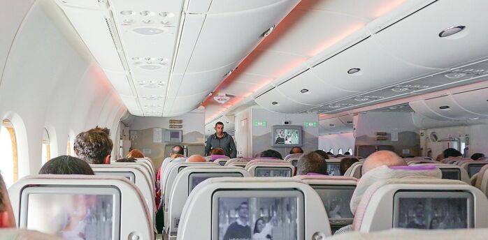 Passengers seated inside an aircraft cabin during a flight