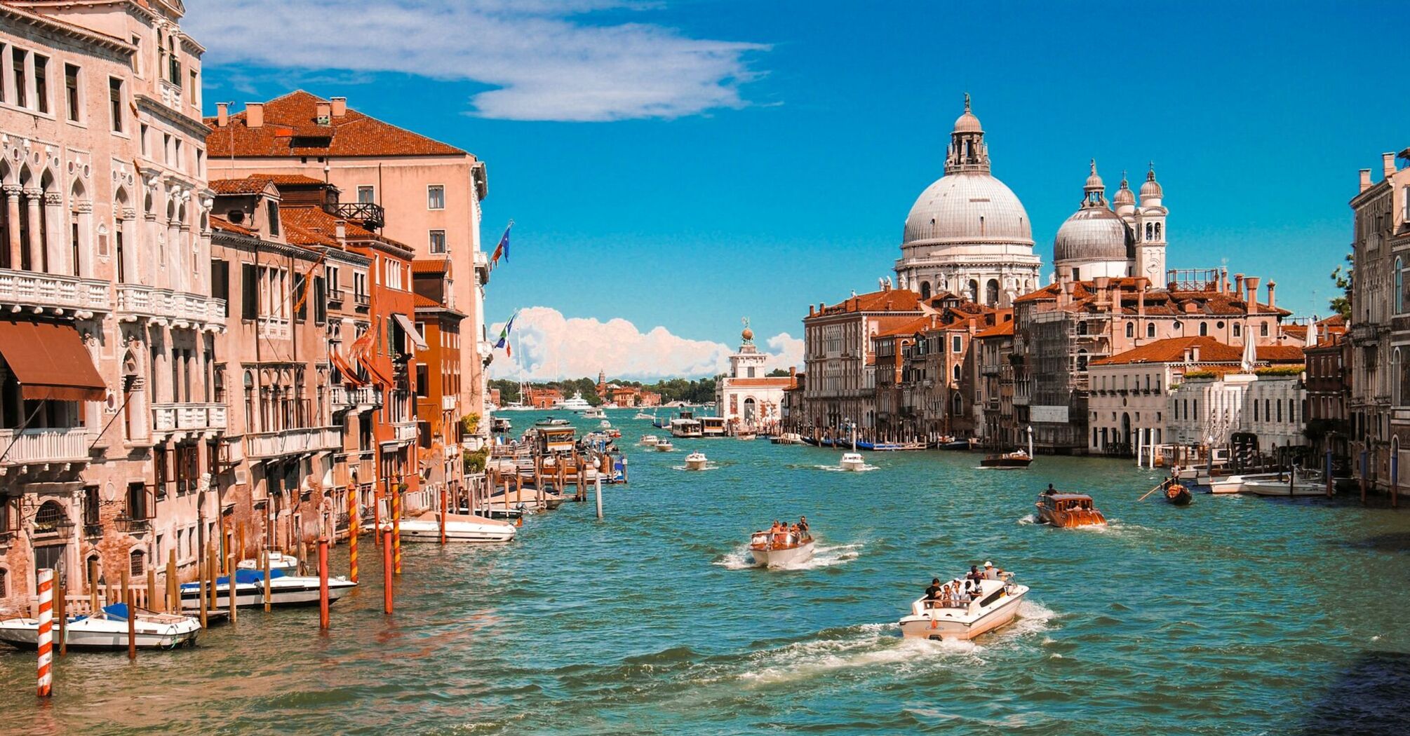 Grand Canal in Venice with boats and historic buildings on a sunny day