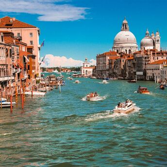 Grand Canal in Venice with boats and historic buildings on a sunny day