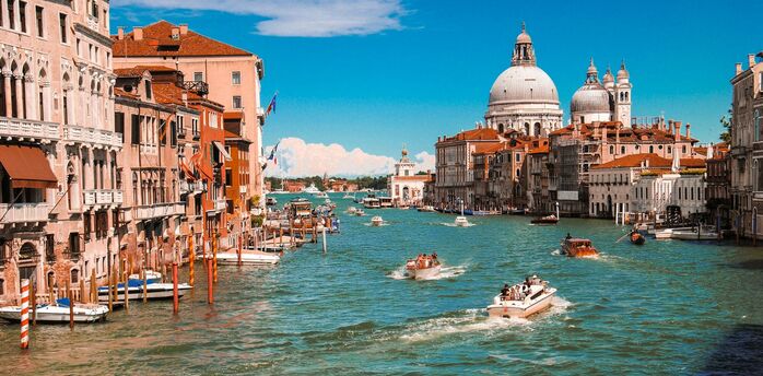 Grand Canal in Venice with boats and historic buildings on a sunny day