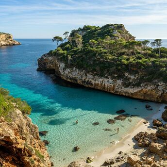 Mallorca cove with clear turquoise water and rocky pine-covered cliffs