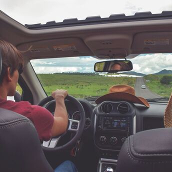 Driver on a summer road trip viewed from inside a car