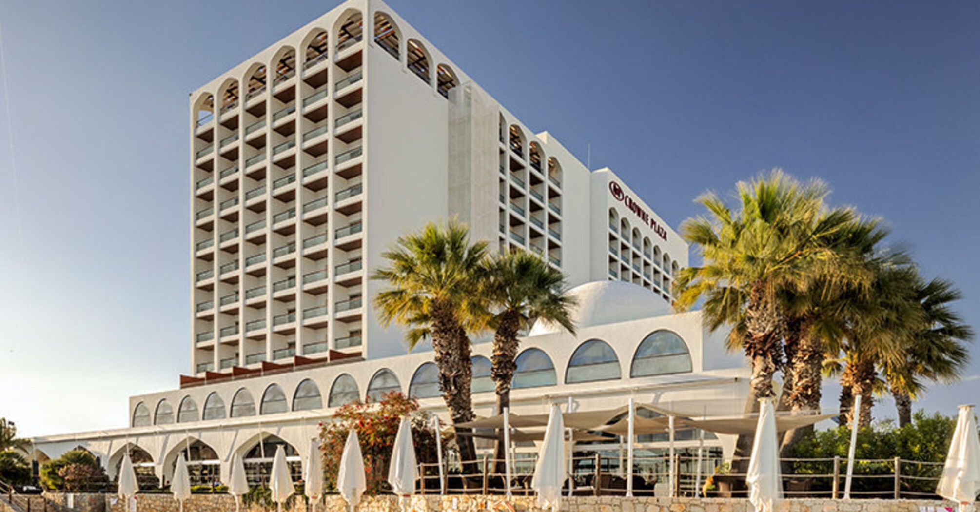 Crowne Plaza hotel building in Vilamoura with palm trees outside