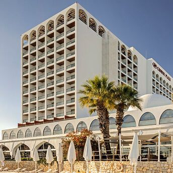 Crowne Plaza hotel building in Vilamoura with palm trees outside
