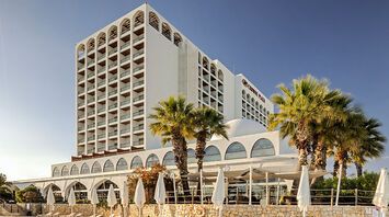 Crowne Plaza hotel building in Vilamoura with palm trees outside