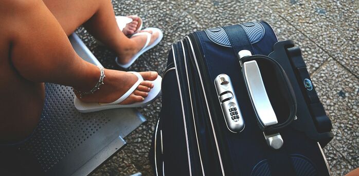 Traveller waiting beside a suitcase