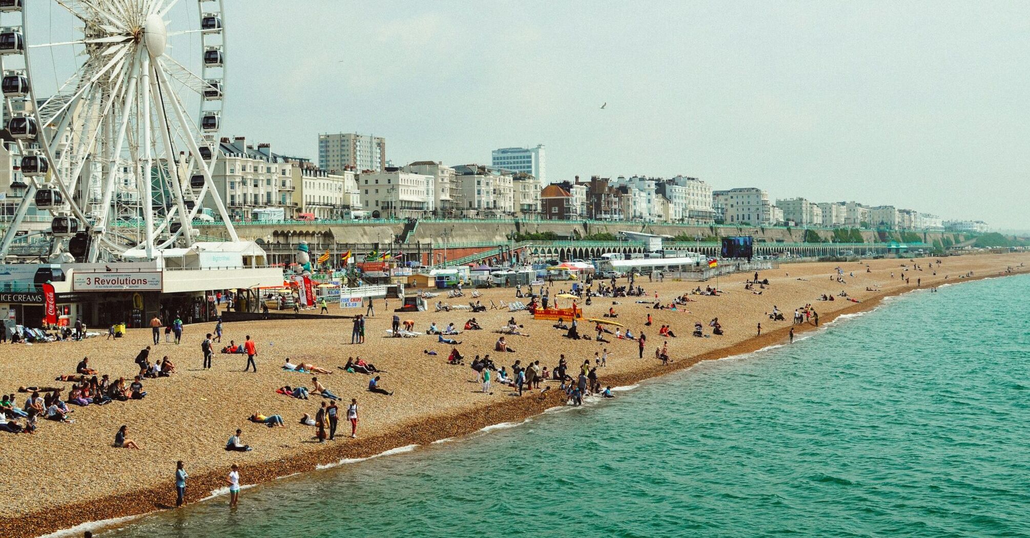 People enjoying Brighton Beach during warm summer weather