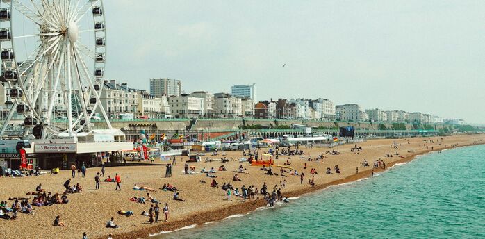 People enjoying Brighton Beach during warm summer weather