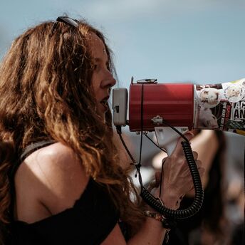 Woman speaking through a megaphone during a public protest