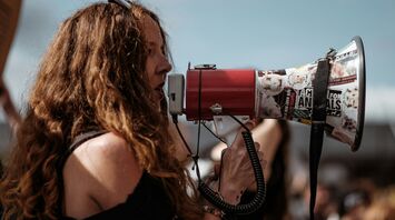 Woman speaking through a megaphone during a public protest