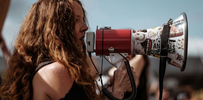 Woman speaking through a megaphone during a public protest