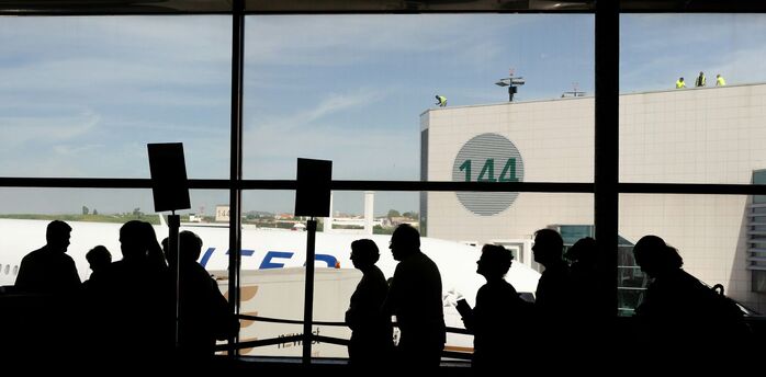 Passengers queueing inside a European airport terminal