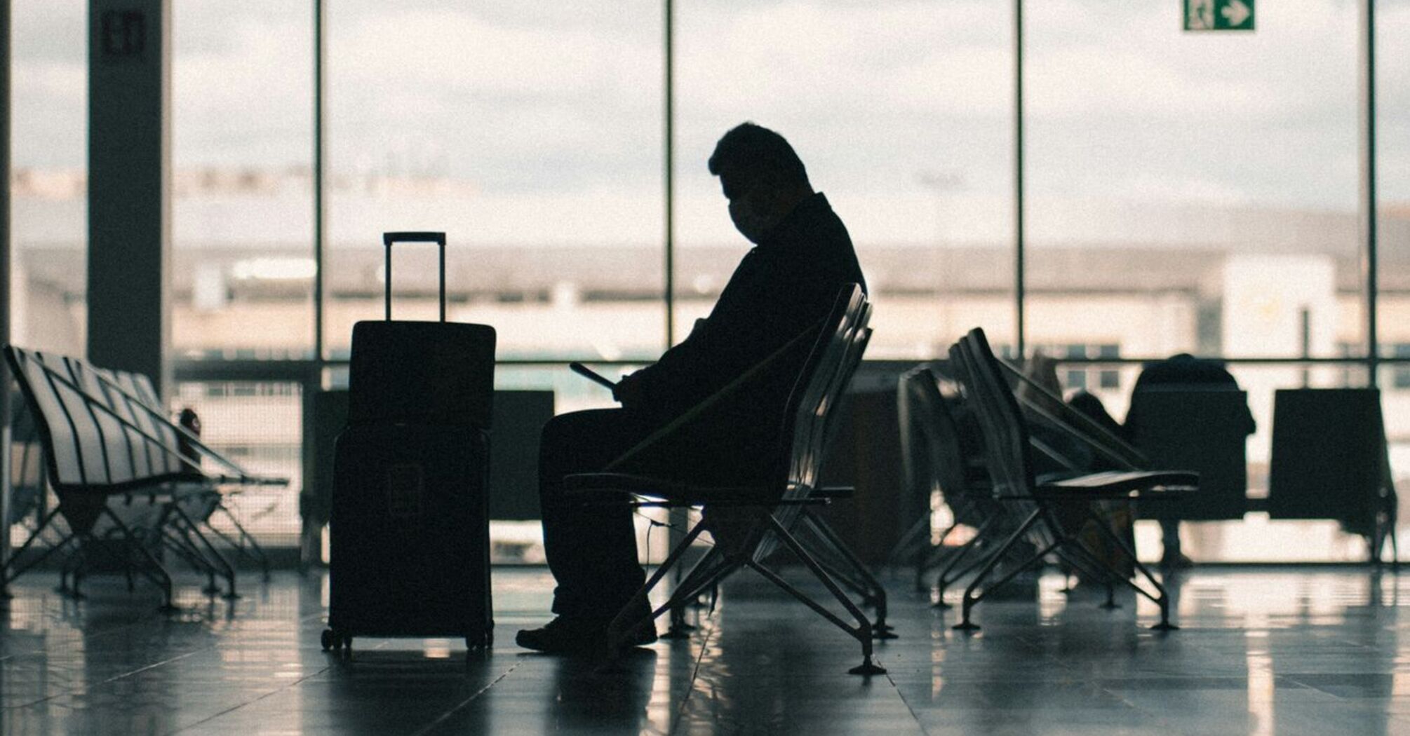 Passenger waiting with luggage in an airport terminal
