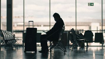 Passenger waiting with luggage in an airport terminal