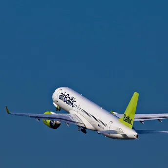 airBaltic aircraft taking off against a clear blue sky