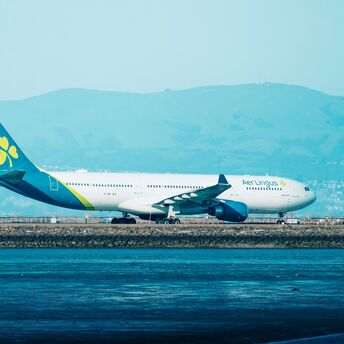 Aer Lingus aircraft on a runway with hills in the background