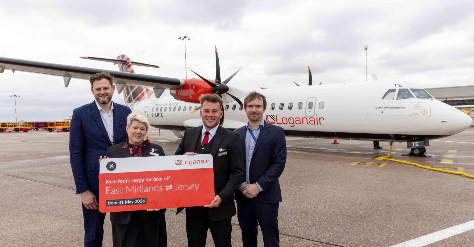Loganair crew and airport staff mark the new East Midlands to Jersey route beside an aircraft