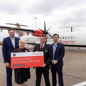 Loganair crew and airport staff mark the new East Midlands to Jersey route beside an aircraft