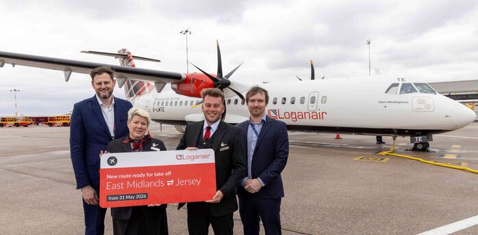 Loganair crew and airport staff mark the new East Midlands to Jersey route beside an aircraft