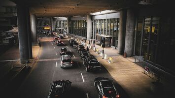 Cars queuing outside an airport terminal drop-off area