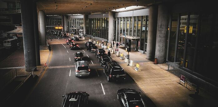 Cars queuing outside an airport terminal drop-off area