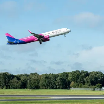 Wizz Air aircraft taking off above an airport runway