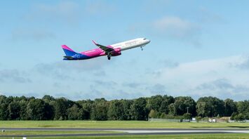 Wizz Air aircraft taking off above an airport runway