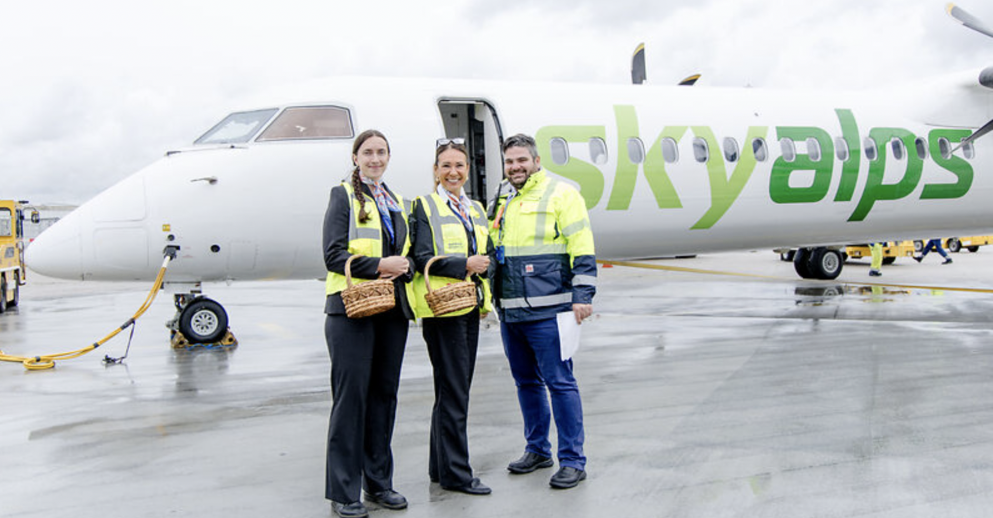 SkyAlps staff standing beside an aircraft at Salzburg Airport