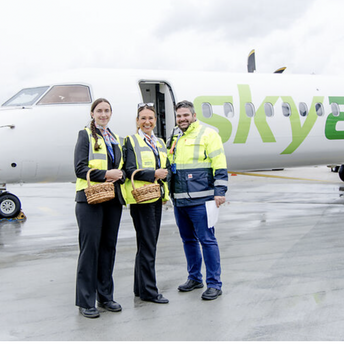 SkyAlps staff standing beside an aircraft at Salzburg Airport