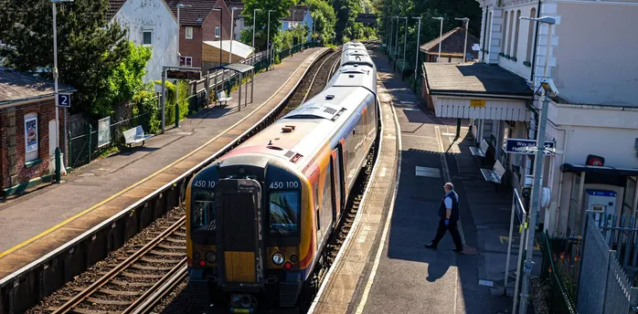 Train at a small UK station platform on a sunny day
