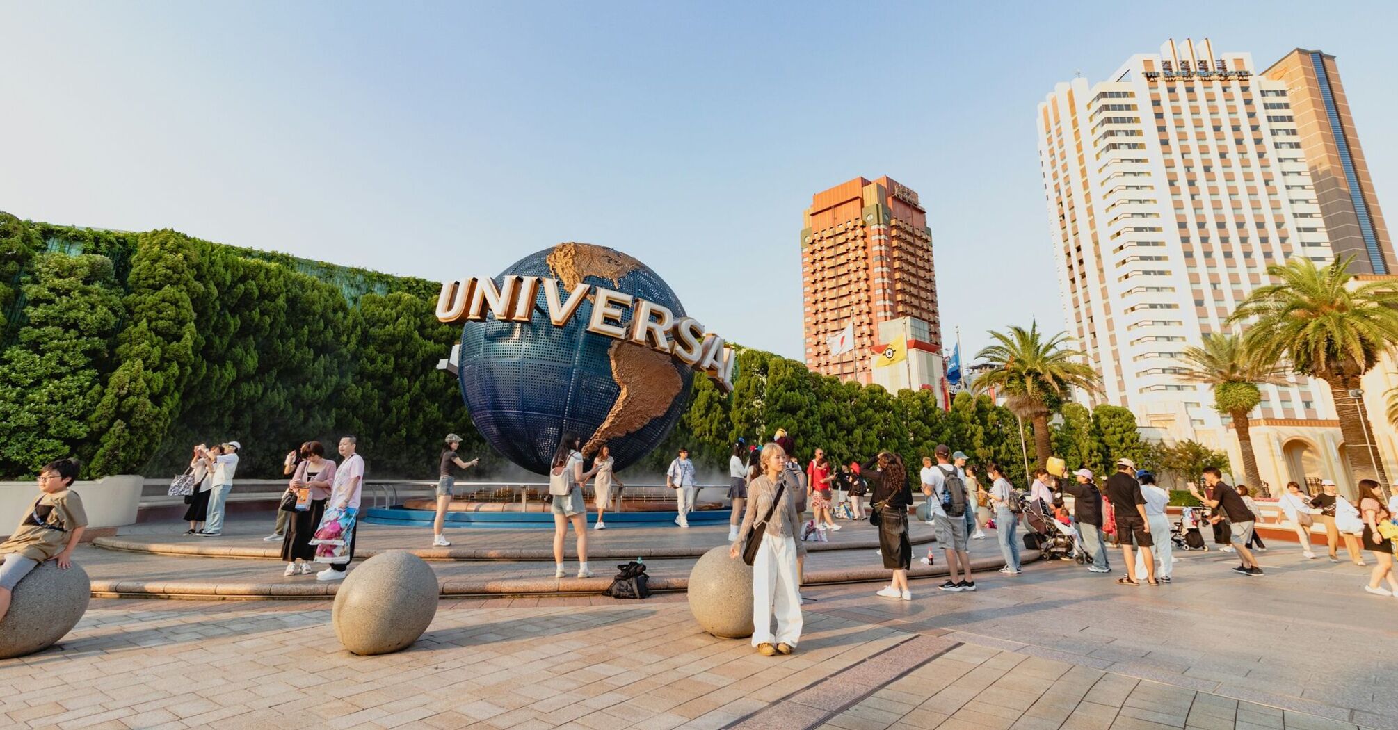 Visitors near the Universal globe at a resort entrance