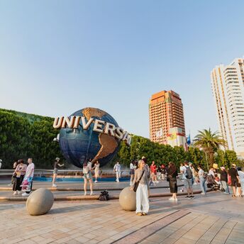 Visitors near the Universal globe at a resort entrance