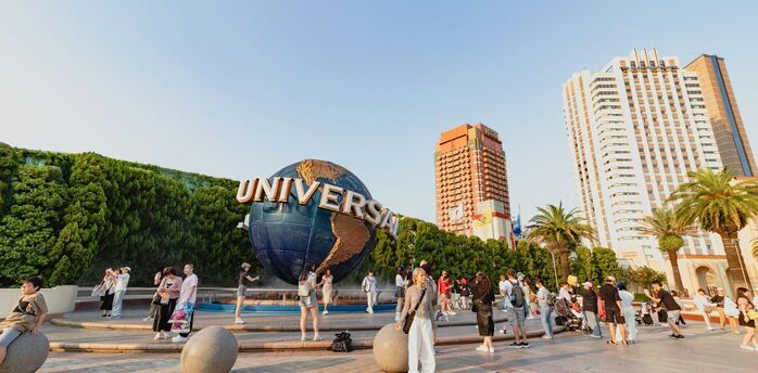 Visitors near the Universal globe at a resort entrance