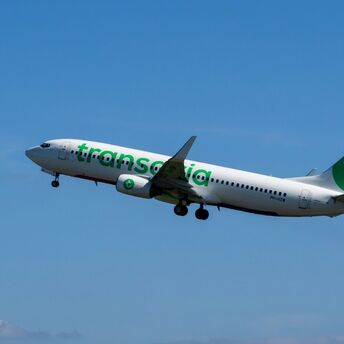 Transavia aircraft flying against a blue sky