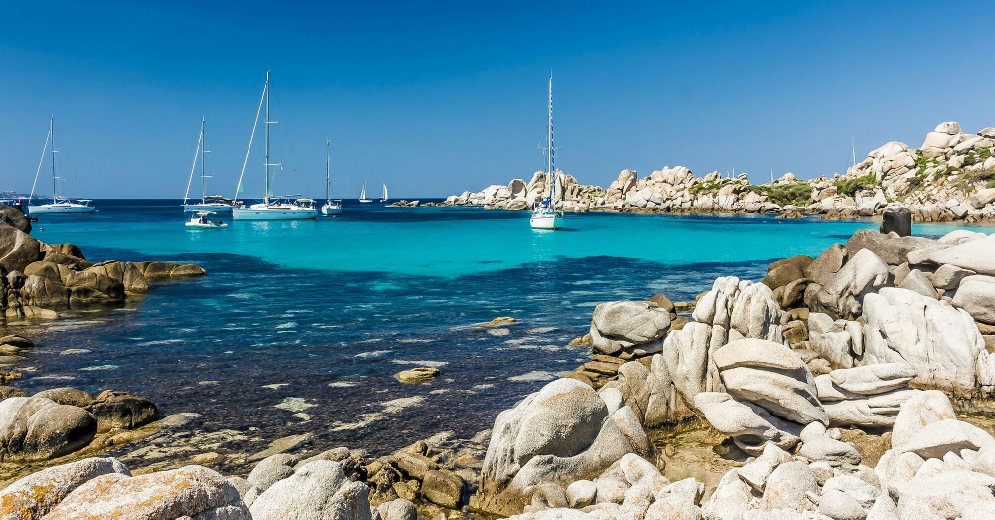 Turquoise bay with yachts and rocky coastline in Corsica